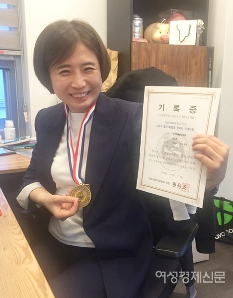 김도연 PRM 대표가 철인3종경기 3.9km 수영완주 기록증을 들고 밝게 웃고 있다. / PRM 제공