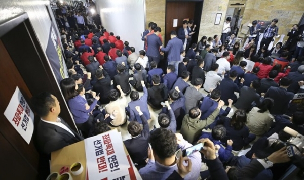 자유한국당 의원들이 29일 오후 국회 정치개혁특위가 열릴 것으로 예고되었던 국회 본청 4층 행정안전위원회 복도에서 정의당 의원들이 지나가지 못하게 누워서 길을 막고 있다. 정치개혁특위는 잠시 후 6층 정무위 회의장에서 열렸다./연합뉴스