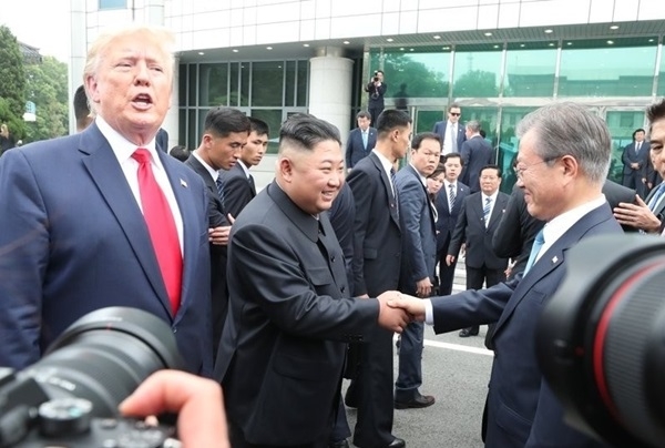 도널드 트럼프 미국 대통령과 문재인 대통령이 30일 오후 판문점 군사분계선 남측 자유의 집 인근에서 북한 김정은 국무위원장과 만나 악수하고 있다/연합뉴스