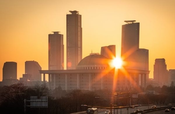 서울 여의도 국회의사당 너머로 아침해가 떠오르고 있다. / 연합뉴스