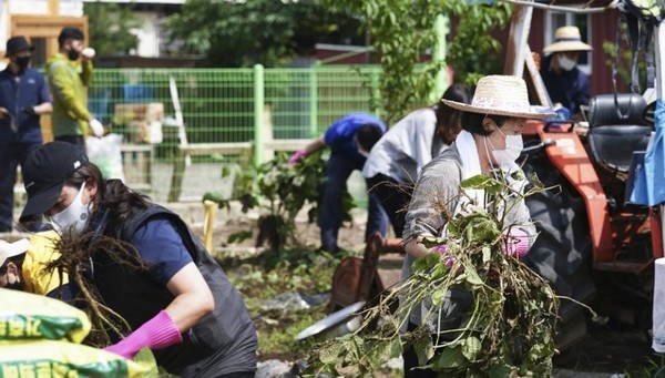 김정숙(오른쪽) 여사가 지난 12일 강원 철원군 동송읍 이길리 마을에서 수해 복구 봉사활동을 하는 모습. / 청와대