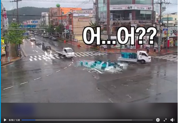 소줏병을 싣고 가던 트럭이 교차로에서 좌회전하면서 소줏병과 소주 박스들을 도로에 떨어뜨리고 있다./포항북부경찰서 유튜브 화면 캡처.