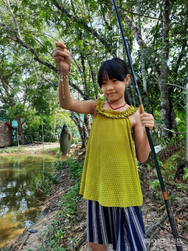 초중고는 코로나19로 7개월째 휴교 중이다. 엔젤라는 집에서 골프, 그림, 낚시를 한다. 아빠가 뒷뜰에 간이 골프연습장을 만들어주었다(위). 우기가 끝나 마을에 호수가 생겨 낚시를 한다(아래).