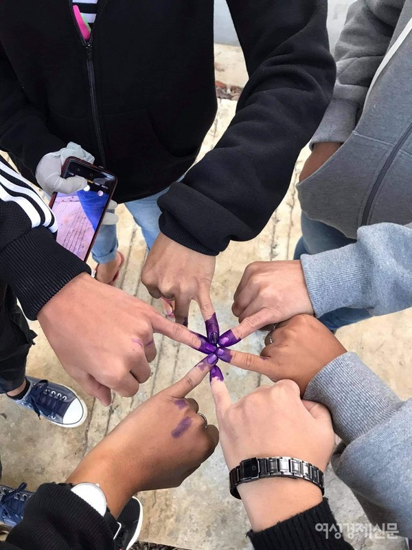 새끼손가락의 보랏빛 물감들. 투표가 끝나면 이 물감을 찍는다. 지워지는데 며칠 걸린다. 재투표를 못하도록 방지하는 의미도 있다.