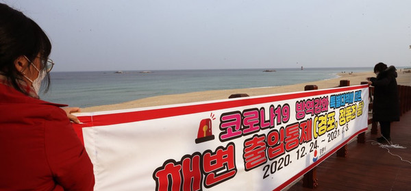 연말연시 해맞이 관광객에 의한 코로나19 대확산이 우려되자 23일 강원 강릉시가 경포 해변 주변에 출입을 차단한다는 현수막을 걸고 있다. /연합뉴스