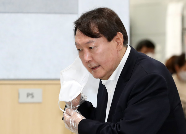 대권주자 선호도 여론조사 1위에 올라있는 윤석열 검찰총장이 메시지를 던지고 물밑으로 사라지는 '메시지 놀이'를 중지하고 즉각 출마선언을 해서 국민적 검증을 받아야 한다는 주장이 제기되고 있다. 윤 전 검찰총장이 4·7 서울시장 보궐선거 사전투표 첫날인 4월 2일 서울 서대문구 남가좌1동 주민센터에 마련된 사전투표소에서 신분 확인을 위해 마스크를 내리고 있다. /연합뉴스