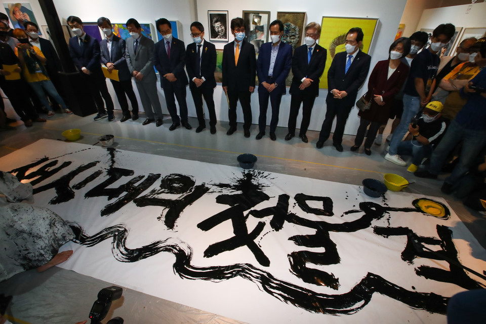 5월 23일이면 노무현 전 대통령 서거 12주년이 된다.  노 전 대통령은 ‘사람’이라는 가치를 정치의 중심에 최초로 끌어온 인물이다.  사진은 정세균 전 국무총리와 이재명 경기도지사 등 참석자들이 5울 19일 서울 종로구 인사동 마루아트센터에서 열린 노무현 서거 12주기 추모전시에 참석해 권도경 작가의 캘리그라피 퍼포먼스를 보고 있는 모습. /연합뉴스