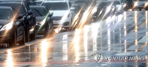 비가 내린 서울 시내에서 차들이 전조등을 켜고 있다./ 연합뉴스