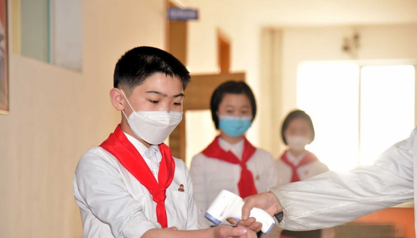 북한 조선중앙통신이 최근 보도한, 평양 낙랑구역 충성초급중학교에서 학생들이 마스크를 쓴 채 체온을 재고 있는 모습./ 연합뉴스