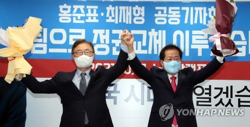 국민의힘 홍준표 대선 경선 후보(오른쪽)와 최재형 전 감사원장(왼쪽)이 17일 오전 서울 여의도 홍준표 캠프 사무실에서 열린 최 전 감사원장 영입 행사에서 꽃다발을 들고 포즈를 취하고 있다. /국회사진기자단=연합뉴스