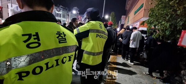 31일 자정이 넘은 시각, 이태원 거리의 인파 속에 경찰이 서 있다. 경찰은 이태원에 몰려든 시민들에 해산명령만 할 뿐 단속은 하지 못하고 있는 상황이다. / 김현우 기자