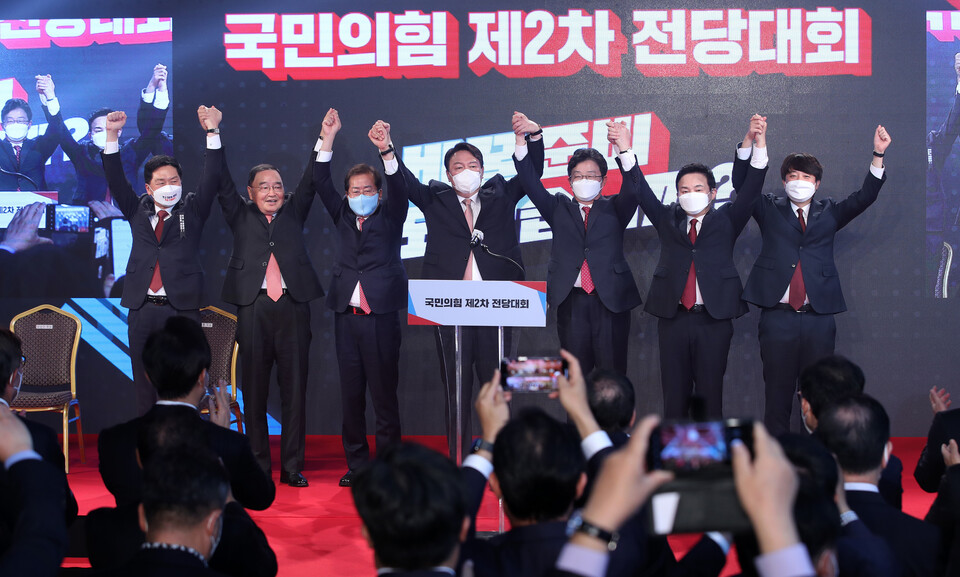 국민의힘 대선 후보로 선출된 윤석열 후보가 5일 서울 용산구 백범김구기념관에서 열린 국민의힘 전당대회에서 손을 들어 인사하고 있다. 왼쪽부터 김기현 원내대표, 정홍원 선거관리위원장, 홍준표 경선 후보, 윤 후보, 유승민 경선 후보, 원희룡 경선 후보, 이준석 대표.  / 연합뉴스