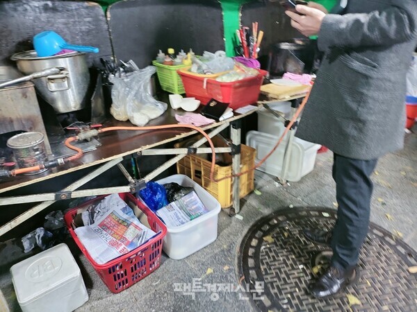 포장마차 내부 모습. 식사를 마친 손님이 카드 계산기가 따로 없어 계좌이체를 하고 있는 모습./김현우 기자