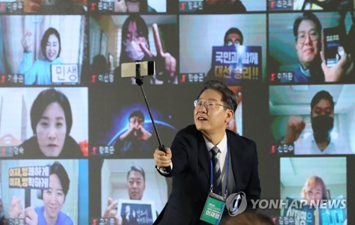더불어민주당 이재명 대선후보가 29일 광주시 서구 김대중컨벤션센터에서 열린 전국민 선대위회의에서 참석자들과 함께 셀카봉으로 직접 기념촬영을 하고 있다. /연합뉴스