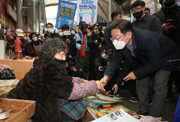 더불어민주당 이재명 대선 후보가 13일 경북 포항시 북구 죽도시장을 찾은 자리에서 상인과 인사하고 있다. 이 후보의 지방 유세는 각 시도단위별 팬클럽을 중심으로 미리 현장에 우호적 분위기를 만들고 철저하게 동선과 시간을 체크해 후보와 국민들 간 스킨십을 최대한 유도해 좋은 반응을 얻고 있다. /연합뉴스