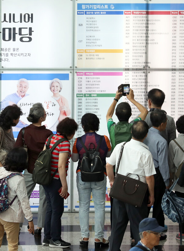 2018년 9월 19일 부산 해운대구 벡스코에서 열린 '60+ 시니어일자리한마당'에서 구직을 원하는 노인들이 채용정보를 살펴보고 있다. 부산시가 고령화 시대를 맞아 시니어에게 취업정보와 취업기회를 제공하고자 마련한 이 행사에는 115개사 200개 부스 규모로 참가해 장·노년 구직자 1238명을 채용했다. /연합뉴스