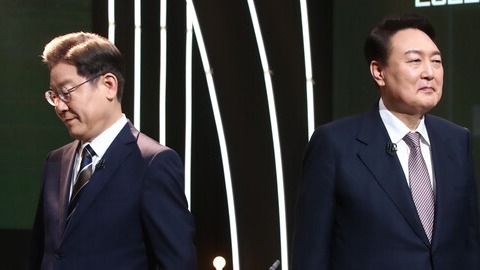 3일 오후 서울 여의도 KBS 공개홀에서 열린 방송 3사 합동 초청 '2022 대선후보 토론'에서 이재명 더불어민주당 대선후보(왼쪽)가 기념촬영을 마친 뒤 자리로 돌아가고 있다. 오른쪽은 윤석열 국민의힘 대선후보. /국회사진기자단=연합뉴스