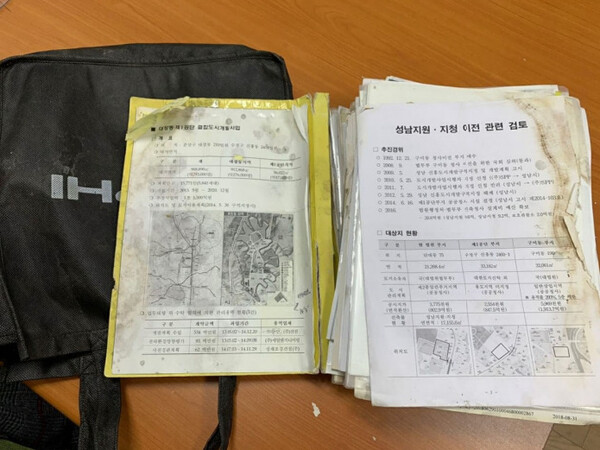 제2경인고속도로 부근 배수로에 버려져 있는 검은색 가방과 대장동 관련 문건. /국민의힘 제공