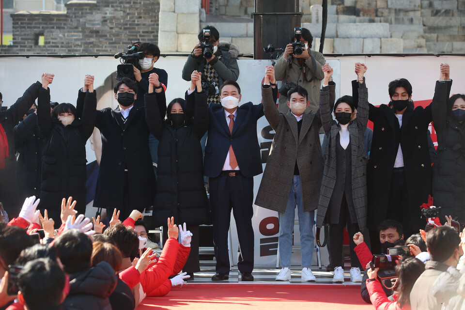 국민의힘 윤석열 대선후보가 24일 오후 경기도 수원시 팔달문 앞에서 열린 수원 집중유세에서 청년들과 손을 맞잡아 들고 지지를 호소하고 있다. /연합뉴스