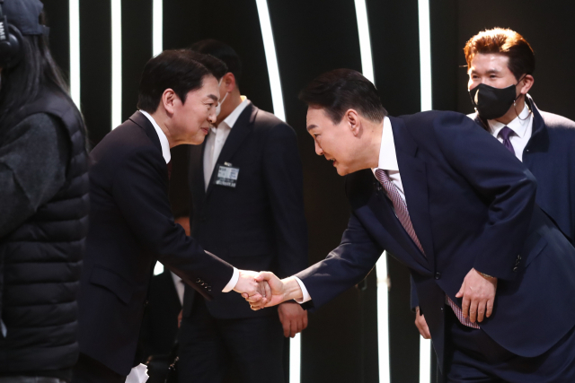 안철수 국민의당 대선후보와 윤석열 국민의힘 대선후보가 한 행사장에서 인사를 나누고 있다. /연합뉴스