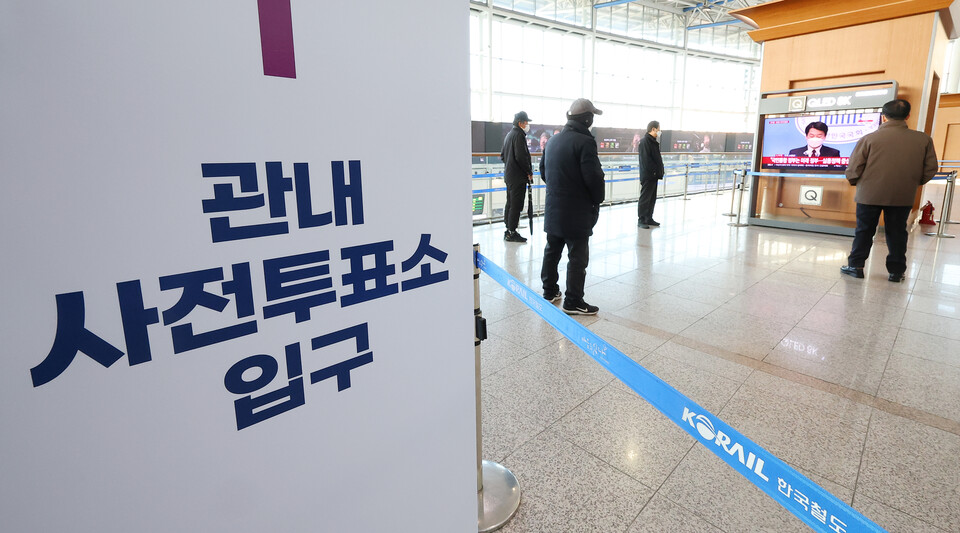 제20대 대선 사전투표를 하루 앞둔 3일 오전 사전투표소가 마련된 서울역 대합실 부근에서 시민들이 윤석열-안철수 후보 단일화 기자회견을 지켜보고 있다. / 연합뉴스