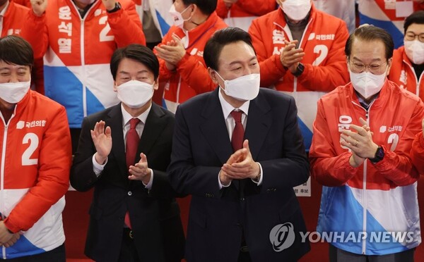 윤석열 제20대 대통령 당선인이 10일 새벽 서울 여의도 국회도서관에 마련된 '국민의힘 제 20대 대통령선거 개표상황실'을 찾아 박수를 치고 있다. 왼쪽 두번째는 국민의당 안철수 대표. /국회사진기자단=연합뉴스