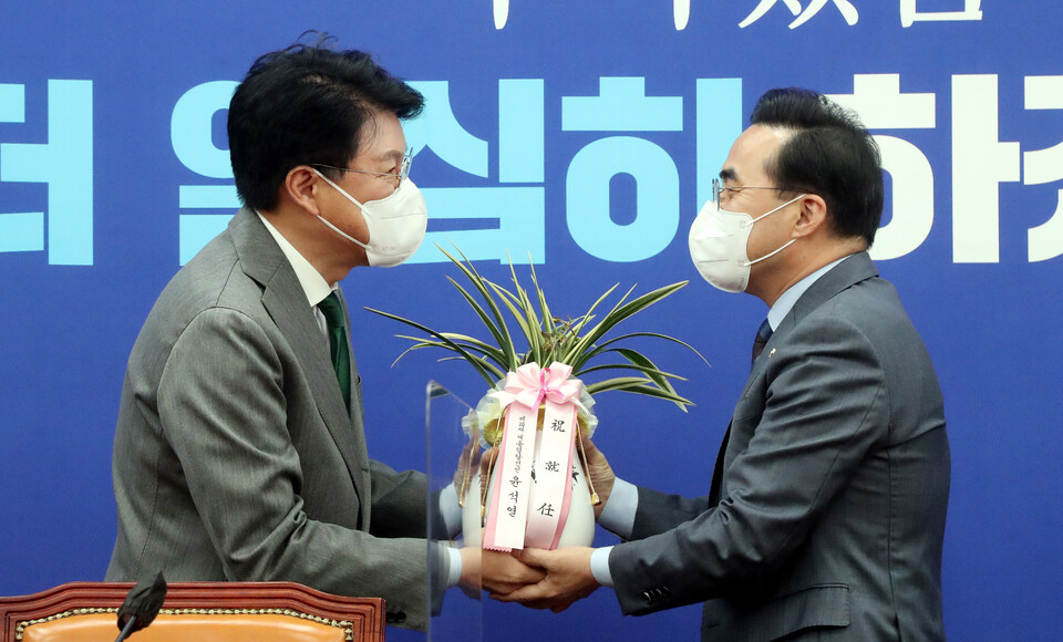 더불어민주당 박홍근 신임 원내대표(오른쪽)가 25일 서울 여의도 국회 원내대표 회의실에서 장제원 대통령 당선인 비서실장으로부터 윤석열 대통령 당선인의 축하 난을 받고 있다. / 연합뉴스