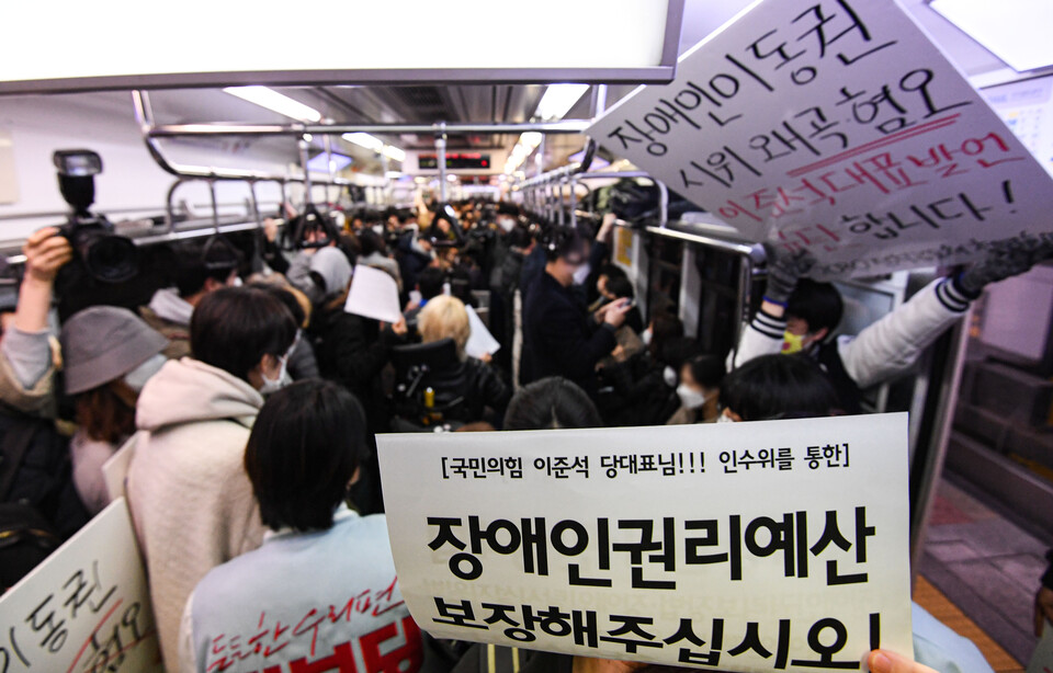 전국장애인차별철폐연대(전장연) 회원들과 시민단체가 28일 서울 3호선 지하철에서 장애인 이동권 보장·장애인 권리예산 반영을 요구하며 출근 시간대 지하철 시위 '출근길 지하철 탑니다'를 하고 있다. /연합뉴스
