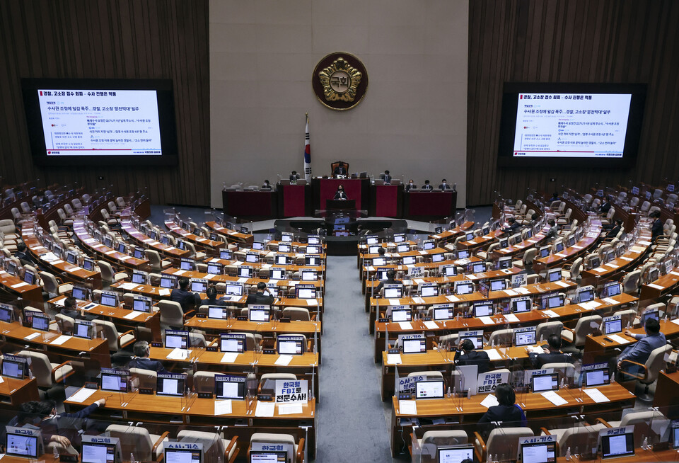 국민의힘 김미애 의원이 30일 저녁 국회 본회의에서 형사소송법 개정안에 대한 반대 무제한토론을 하던 중 전광판에 고소 접수 관련 민원을 제기한 기사 목록을 보여주고 있다. /연합뉴스