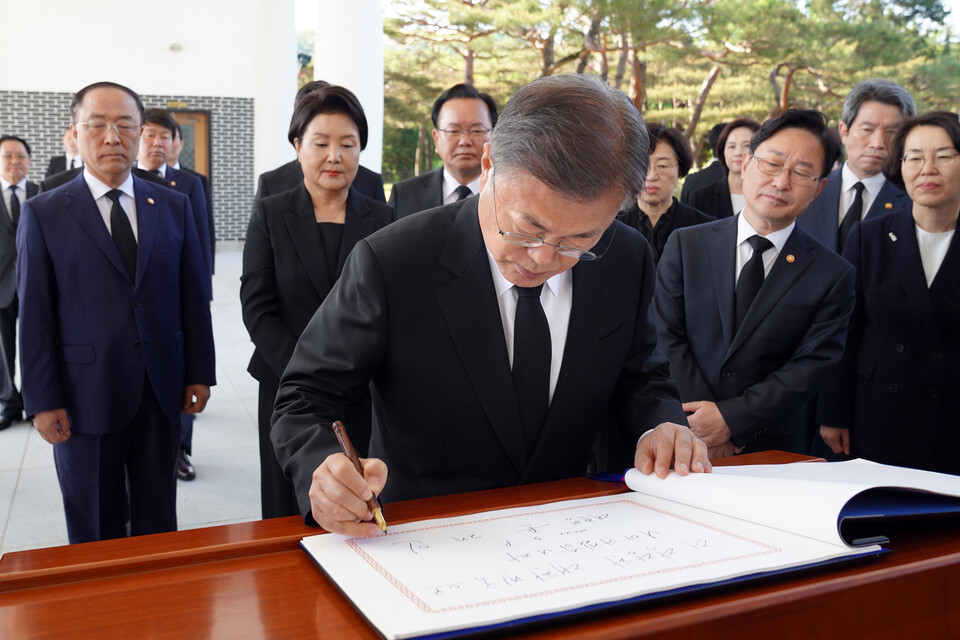 문재인 대통령이 9일 오전 서울 동작구 국립서울현충원 내 현충탑을 참배한 뒤 방명록에 글을 남기고 있다. / 연합뉴스
