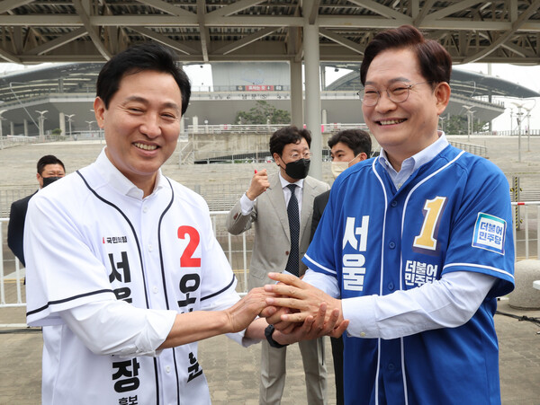 국민의힘 오세훈 서울시장 후보와 더불어민주당 송영길 서울시장 후보가 21일 오전 서울시 마포구 월드컵경기장 평화의 광장에서 열린 2022 서울신문 마라톤 대회에서 손을 잡고 있다. /연합뉴스