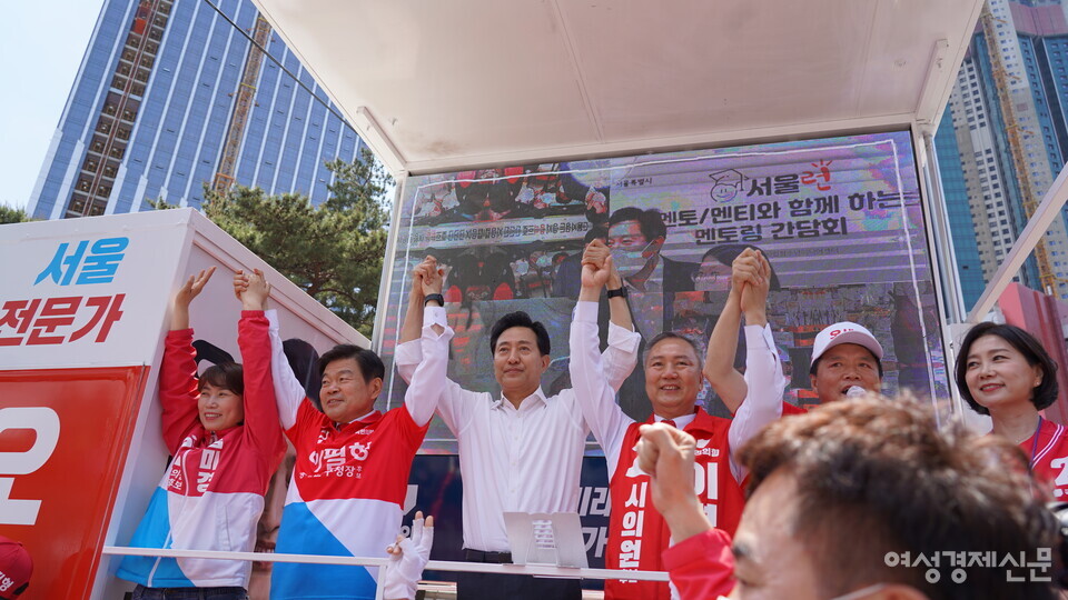 27일 서울 동대문구 제기동 경동시장 사거리에서 국민의힘 오세훈 서울시장 후보가 이필형 동대문구청장 후보, 이병윤 심미경 시의원 후보와 손을 맞잡고 지지를 호소하고 있다. /최수빈 기자