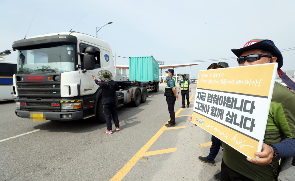 화물연대 총파업 이틀째인 8일 오전 인천시 연수구 인천항 신국제여객터미널 화물터미널 입구에서 화물연대 인천지역본부 조합원들이 비조합원의 트럭을 세운 뒤 운송을 멈춰 총파업에 힘을 보태달라는 요청을 하고 있다. /연합뉴스