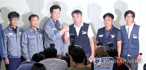 대우조선해양 하청 노사협상이 극적으로 타결된 22일 경남 거제시 대우조선해양 옥포조선소에서 협력사 대표들과 하청노조 조합원들이 악수하고 있다. 왼쪽 세 번째부터 권수오 녹산기업 대표, 홍지욱 금속노조 부위원장, 윤장혁 금속노조 위원장. /연합뉴스