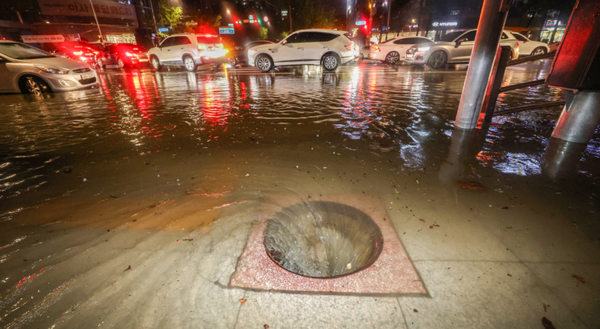 9일 새벽 폭우로 다수의 차량이 침수된 서울 강남구 대치사거리의 배수구가 뚜껑이 없어진 채 소용돌이치고 있다. /연합뉴스