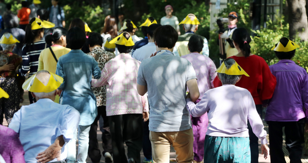 지난 2014년 진행된 '송파구 치매극복 걷기대회'에서 참가 어르신들이 가족과 함께 서울 석촌호수를 따라 걷고 있다. /연합뉴스