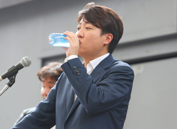 국민의힘 이준석 전 대표가 4일 오후 대구 중구 김광석 거리에서 당원들과 만나 발언하던 중 물을 마시고 있다. 이 전 대표는 기자회견 방식으로 지역 당원들과 시민들을 만났다. /연합뉴스