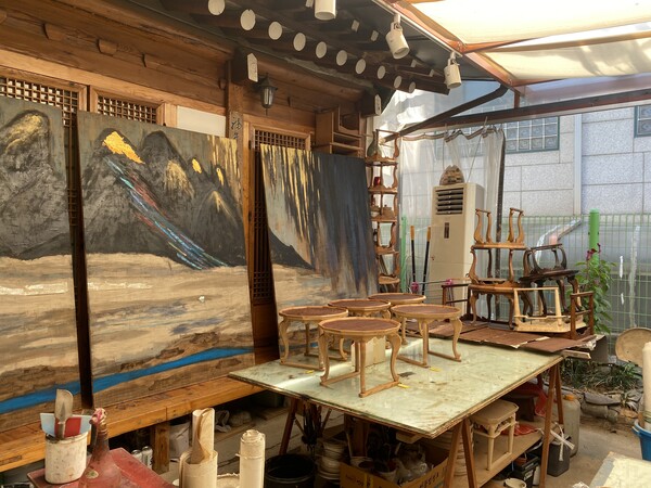 소반 만들기를 하는 서로재 마당. 10월 12일에 열리는 '서로재 이야기 II' 전시회에 출품 예정인 나성숙 교수의 대형 옻칠화 작품 '그리운 북한 산하'의 일부가 보인다. /사진=민은미