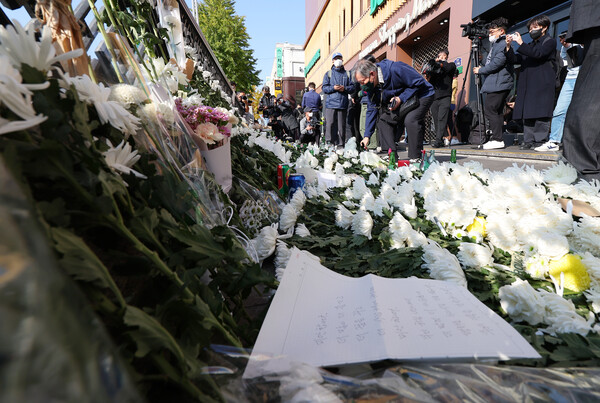 10월 31일 오전 서울 용산구 지하철 6호선 이태원역 1번 출구 앞에 마련된 '핼러윈 인파' 압사 사고 희생자 추모 공간을 찾은 시민이 헌화하고 있다. /연합뉴스