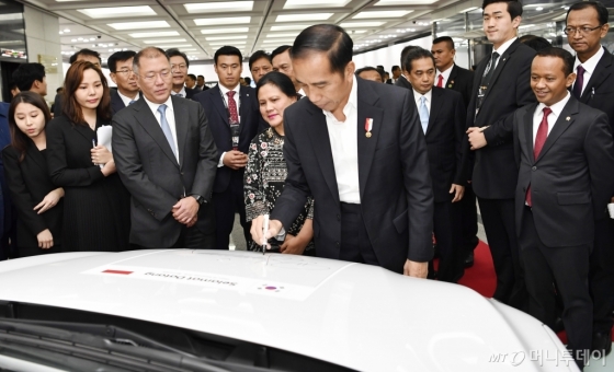 2019년 11월 26일 현대자동차 울산공장에서 열린 현대자동차 인도네시아 공장 설립 투자협약식 전에 조코 위도도 인도네시아 대통령이 정의선 현대자동차그룹 수석부회장(왼쪽 3번째)이 지켜보는 가운데 코나 일렉트릭에 기념 서명을 하고 있다. /현대차