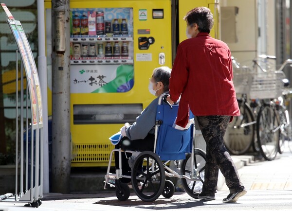일본 도쿄에서 한 고령자가 휠체어를 타고 이동하고 있다. /연합뉴스
