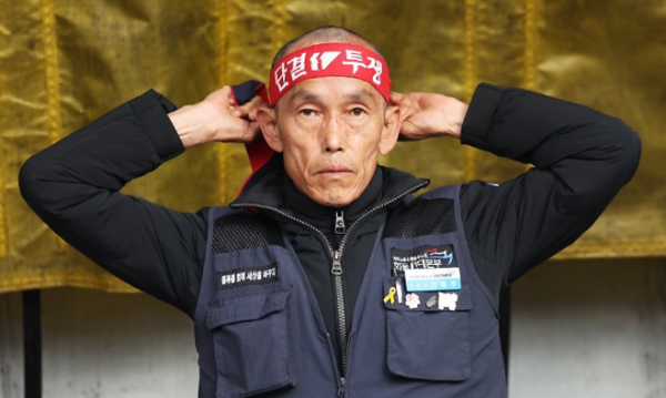 파업에 나선 이봉주 화물연대 위원장이 '단결 투쟁'이라 적힌 띠를 머리에 매고 있다. /연합뉴스