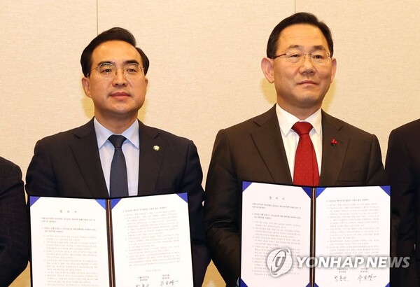 국민의힘 주호영 원내대표(오른쪽)와 더불어민주당 박홍근 원내대표가 22일 오후 서울 여의도 국회에서 열린 내년 예산안·세법 일괄 합의 발표 기자회견에서 합의문을 들고 포즈를 취하고 있다. /연합뉴스