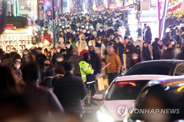 크리스마스 이브인 24일 경찰이 연말 분위기를 즐기는 시민과 차량으로 붐비는 서울 명동거리를 통제하고 있다. /연합뉴스