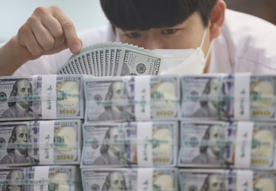 지난 14일 명동 하나은행 위변조대응센터에서 직원이 달러를 정리하고 있다. /연합뉴스