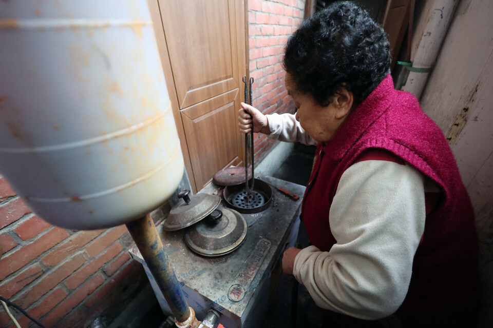 26일 오후 광주 동구 지산2동 한 주택에서 난방 취약계층 노인이 연탄불을 살펴보고 있다. 사진은 기사와 관련 없음. /연합뉴스