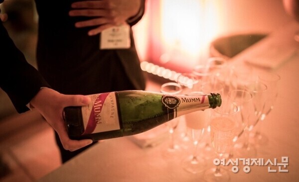 지난달 프랑스 대사관에서 열린 새해 파티에서 한 관계자가 프랑스산 샴페인 G. H. Mumm & Cie를 따르고 있다. /여성경제신문