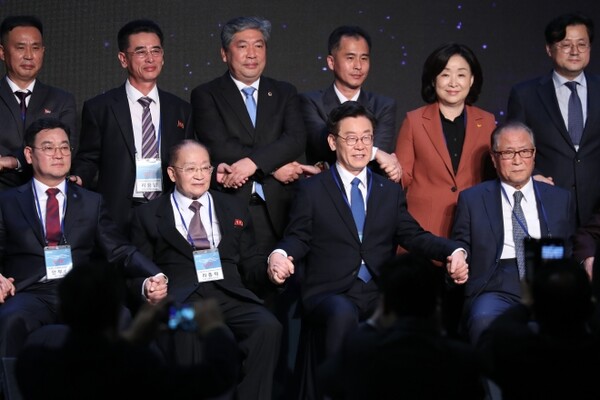 기념촬영하는 리종혁과 이재명. 리종혁 조선아시아태평양평화위원회 부위원장(앞줄 왼쪽에서 두번째)과 이재명 경기도지사(앞줄 오른쪽에서 두번째)가 2018년 11월 16일 오후 경기도 고양시 엠블호텔에서 열린 2018 아시아태평양의 평화번영을 위한 국제대회에서 손을 잡고 기념촬영하고 있다. /연합뉴스