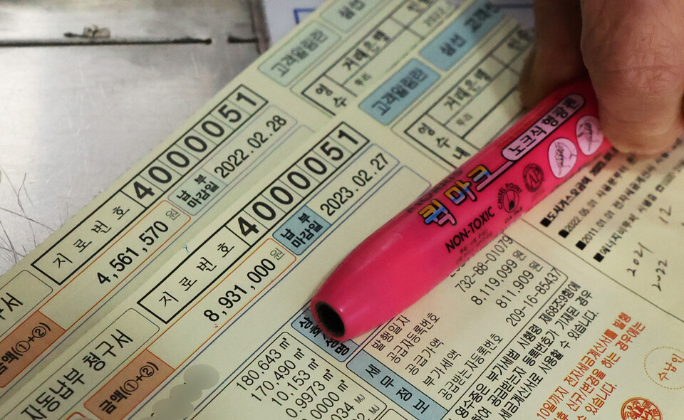 14일 서울 성북구 한 대중목욕탕에서 업주가 올해 1월과 지난해 1월 도시가스 요금 고지서를 보여주고 있다. 업주는 비싸진 가스비에 놀라 작년 1월 고지서를 다시 찾아봤다며 요금이 폭탄 수준이라고 말했다. / 연합뉴스