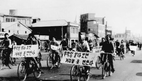 대한가족계획협회 관계자들이 ‘무작정 낳다보면 거지꼴 못 면한다’는 표어를 자전거 앞에 걸고 홍보활동을 하고 있다 /연합뉴스